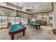 Well-lit game room featuring multiple billiard tables and comfortable seating area at 4557 Bersaglio St, Las Vegas, NV 89135