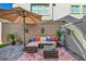 Comfortable backyard patio with cushioned wicker seating, decorative plants, and shade umbrella at 4640 Flower Moon Ave # 102, North Las Vegas, NV 89084