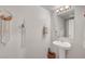 Stylish half bathroom featuring a pedestal sink, decorative mirror, and modern lighting at 4640 Flower Moon Ave # 102, North Las Vegas, NV 89084