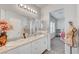 Bright bathroom featuring double sinks, granite countertop, a large mirror and plenty of lighting at 4640 Flower Moon Ave # 102, North Las Vegas, NV 89084