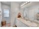 Bright bathroom featuring double sinks, granite countertop, a large mirror and plenty of lighting at 4640 Flower Moon Ave # 102, North Las Vegas, NV 89084