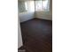 Well-lit bedroom with dark vinyl flooring, neutral walls, and a window at 4770 Topaz St # 79, Las Vegas, NV 89121