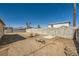 Large, empty backyard with a dirt ground, block wall, aged shed, and utilities at 6120 Cairo Cir, Las Vegas, NV 89107