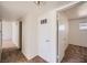 Hallway featuring neutral-toned carpet, white walls, and an open doorway to a well-lit room at 6120 Cairo Cir, Las Vegas, NV 89107