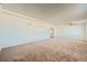 Spacious living room featuring neutral carpet, white walls, and a doorway to the kitchen at 6120 Cairo Cir, Las Vegas, NV 89107