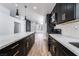 Open kitchen with black cabinets, white countertops, stainless steel appliances, and pendant lighting at 6505 Moon Roses Ct, Las Vegas, NV 89108