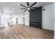 Open-concept living room with fireplace, modern ceiling fan, and hardwood floors leading to the kitchen at 6505 Moon Roses Ct, Las Vegas, NV 89108