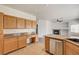 Inviting kitchen featuring wood cabinets, stainless steel appliances, and a granite-topped breakfast bar at 74 Harbor Coast St, Las Vegas, NV 89148