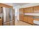 Bright kitchen area featuring stainless steel refrigerator and wooden cabinetry for ample storage at 74 Harbor Coast St, Las Vegas, NV 89148