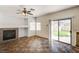 Inviting living room featuring a cozy fireplace, ceiling fan, and sliding glass doors to the yard at 74 Harbor Coast St, Las Vegas, NV 89148