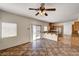 Open-concept living area with a ceiling fan, sliding glass doors to the backyard, and an eat-in kitchen at 74 Harbor Coast St, Las Vegas, NV 89148