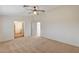 Bright main bedroom with a ceiling fan, carpet, and doorways to the hallway and closet at 74 Harbor Coast St, Las Vegas, NV 89148