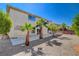 Back exterior view with desert landscaping, palm trees, a patio and access into the home at 7623 Calm Passage Ct, Las Vegas, NV 89139