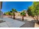 Landscaped backyard with a large patio area, palm trees, and desert-friendly gravel at 7623 Calm Passage Ct, Las Vegas, NV 89139