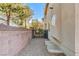 A home exterior with a stone wall and metal gate enclosing a gravel-covered side yard at 7623 Calm Passage Ct, Las Vegas, NV 89139