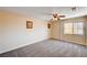 Large carpeted bedroom with ceiling fan and natural light from a large window at 7623 Calm Passage Ct, Las Vegas, NV 89139