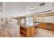 Bright, open kitchen featuring an island with granite countertops, stainless steel appliances, and wood-look flooring at 7623 Calm Passage Ct, Las Vegas, NV 89139