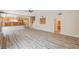 Bright living space with gray wood-look flooring, leading to an open kitchen area at 7623 Calm Passage Ct, Las Vegas, NV 89139