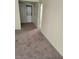 Carpeted room with a stacked washer/dryer and open doorway at 7730 Secret Shore Dr # 207, Las Vegas, NV 89128