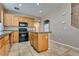 A modern kitchen with wood cabinets, black appliances, and tile flooring at 7978 Light Tower St, Las Vegas, NV 89139