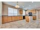 A well-lit kitchen with tile flooring, wood cabinets, and dark appliances at 7978 Light Tower St, Las Vegas, NV 89139