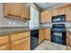 Modern kitchen with wood cabinets, black appliances, and ample counter space at 7978 Light Tower St, Las Vegas, NV 89139