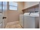 Laundry room with washer, dryer, overhead shelf and tile flooring at 7978 Light Tower St, Las Vegas, NV 89139