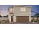 Charming two-story home showcasing a tan stucco facade, a brown garage door and well maintained desert landscaping at 8166 Rockflower St, Las Vegas, NV 89113