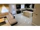 Open living space featuring tile flooring, large sofa, and a seamless transition into a modern kitchen at 8223 Saddleback Ledge Ave, Las Vegas, NV 89147