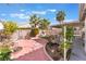 Lush backyard featuring mature trees, colorful flowering plants, and a patio area at 8520 Copper Falls Ave, Las Vegas, NV 89129