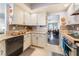 Galley kitchen with modern backsplash, granite countertops, and black appliances at 8520 Copper Falls Ave, Las Vegas, NV 89129