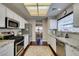 Bright kitchen with white cabinets, granite counters, stainless steel appliances, and a view to the dining area at 8808 Litchfield Ave, Las Vegas, NV 89134