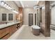 Luxurious bathroom featuring dual vanities, a modern soaking tub, and a separate glass-enclosed shower at 9 Stonecutter Ct, Henderson, NV 89012