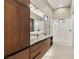 Contemporary bathroom featuring dual sinks with marble countertop, a walk-in shower, and plenty of cabinet space at 9 Stonecutter Ct, Henderson, NV 89012