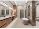 Luxurious bathroom featuring double vanity, modern lighting, freestanding tub, and a glass-enclosed shower at 9 Stonecutter Ct, Henderson, NV 89012