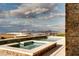 Gorgeous pool with a spa, surrounded by a patio and lush landscaping, offering stunning views of the city and mountains at 9 Stonecutter Ct, Henderson, NV 89012