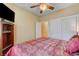 Cozy bedroom with a red comforter, ceiling fan, and built-in shelves for storage at 917 Collingtree St, Las Vegas, NV 89145