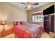 Cozy bedroom with a red comforter, ceiling fan, and natural light at 917 Collingtree St, Las Vegas, NV 89145