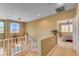 A carpeted hallway and staircase that overlook a bedroom with natural light at 917 Collingtree St, Las Vegas, NV 89145