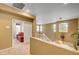 A bright, carpeted hallway leading to a bedroom with a red comforter at 917 Collingtree St, Las Vegas, NV 89145