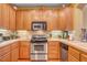 Well-equipped kitchen features wooden cabinets, stainless steel appliances and tiled backsplash at 917 Collingtree St, Las Vegas, NV 89145