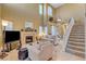 Bright living room featuring a fireplace, high ceilings, and staircase leading to the second floor at 917 Collingtree St, Las Vegas, NV 89145