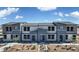 Modern townhomes with a two-story facade, neutral color palette, and xeriscaped front yards under a blue sky at 9355 Jade Mesa St # 52, Las Vegas, NV 89139