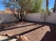 Backyard featuring a xeriscaped area with rock cover, trees, and a block wall at , Henderson, NV 89074