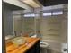 Bathroom featuring a wood vanity with a glass vessel sink and a shower-tub combo with white walls at , Henderson, NV 89074