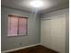 Bedroom featuring neutral walls, wood floors, window with blinds, and a double-door closet at , Henderson, NV 89074