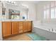 Bright bathroom with double sinks, a soaking tub, and natural light at 1009 Via Canale Dr, Henderson, NV 89011