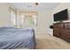 Bedroom featuring a bed, TV, dresser, and a large window with curtains at 1009 Via Canale Dr, Henderson, NV 89011