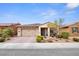 Single-story home featuring a neutral-toned exterior, covered porch, and a well-maintained front yard at 1009 Via Canale Dr, Henderson, NV 89011