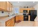 Traditional kitchen featuring wooden cabinets and black appliances at 1009 Via Canale Dr, Henderson, NV 89011
